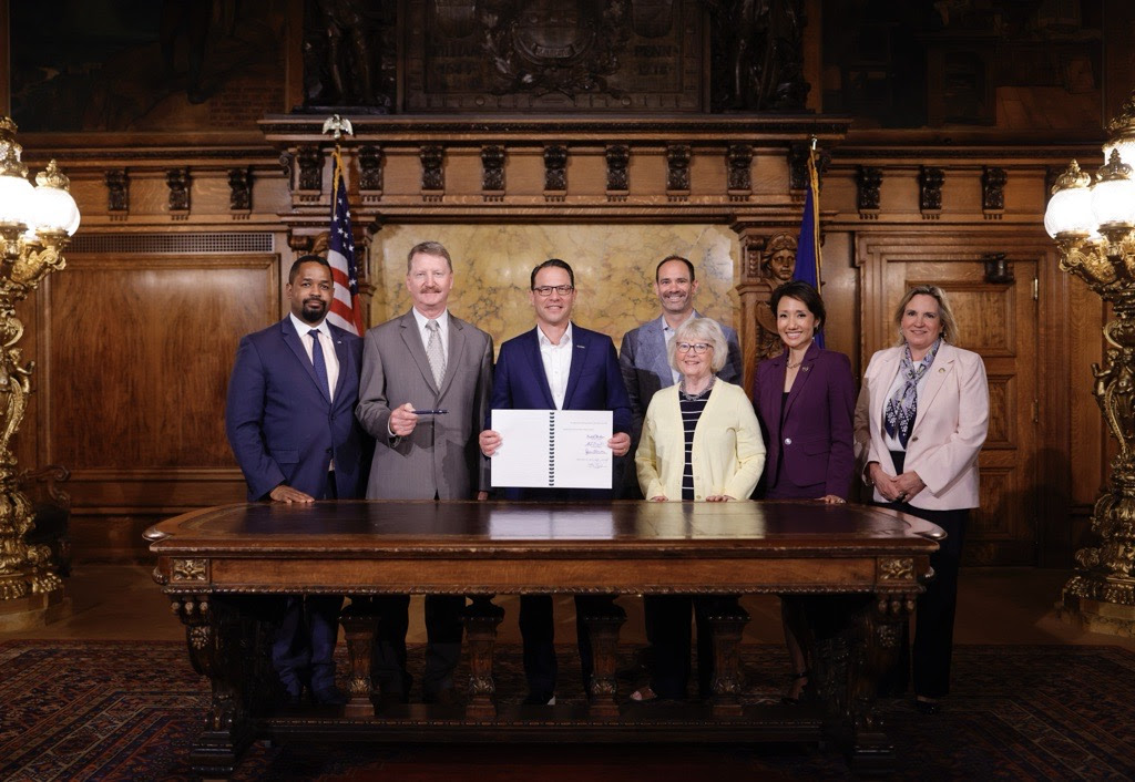 Gov. Josh Shapiro poses with state lawmakers and Insurance Commissioner Michael Humphreys at a bill signing celebrating Act 42 of 2024.